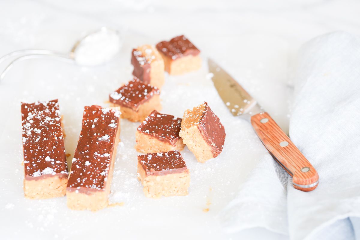 No bake cookie butter bars on a marble countertop, a knife for cutting them nearby.