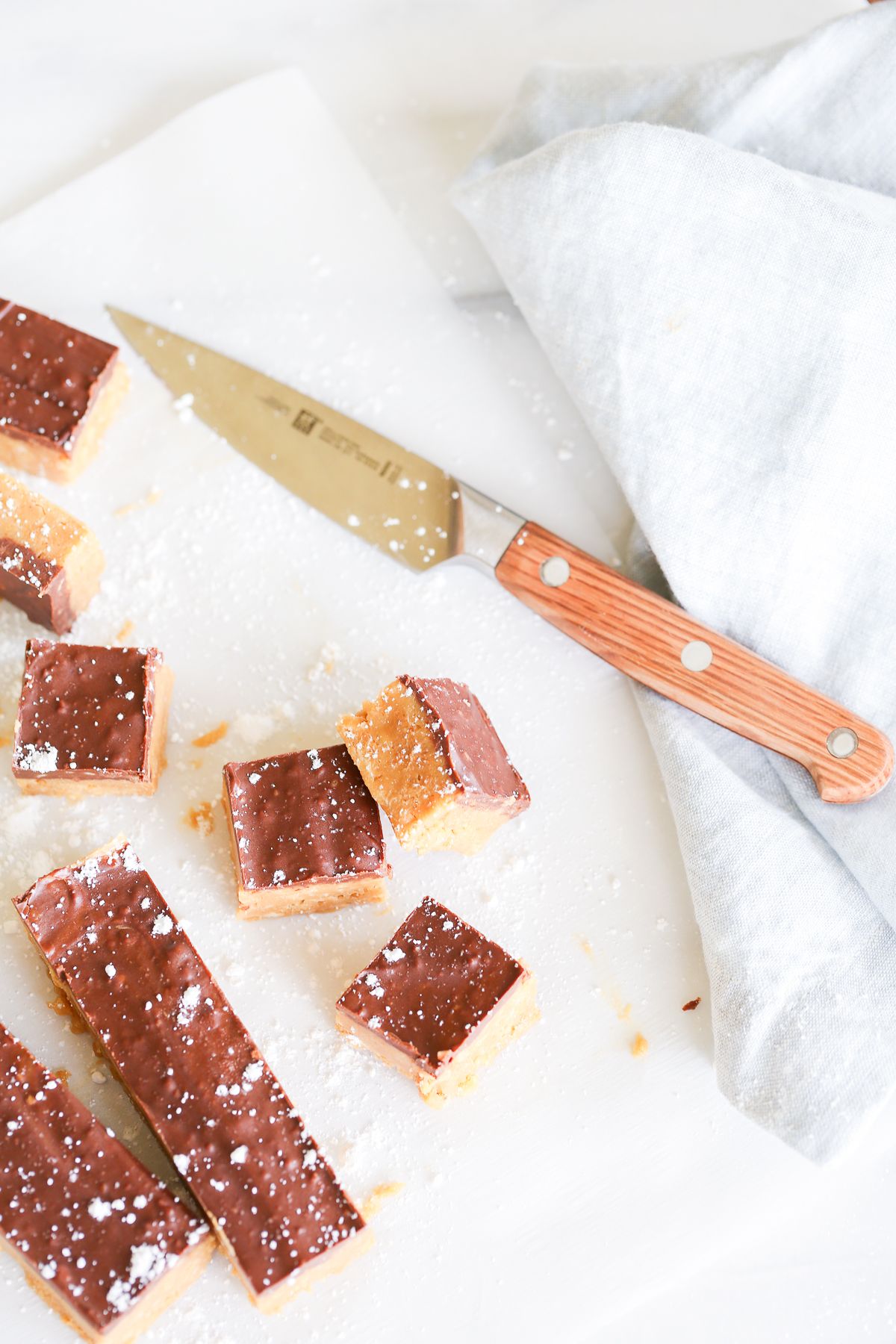 No bake cookie butter bars on a marble countertop, a knife for cutting them nearby.