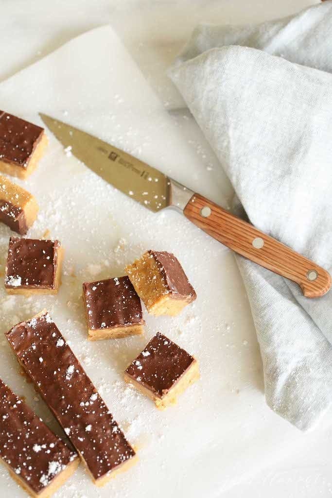 squares of speculoos cookie butter bars on parchment paper with a knife