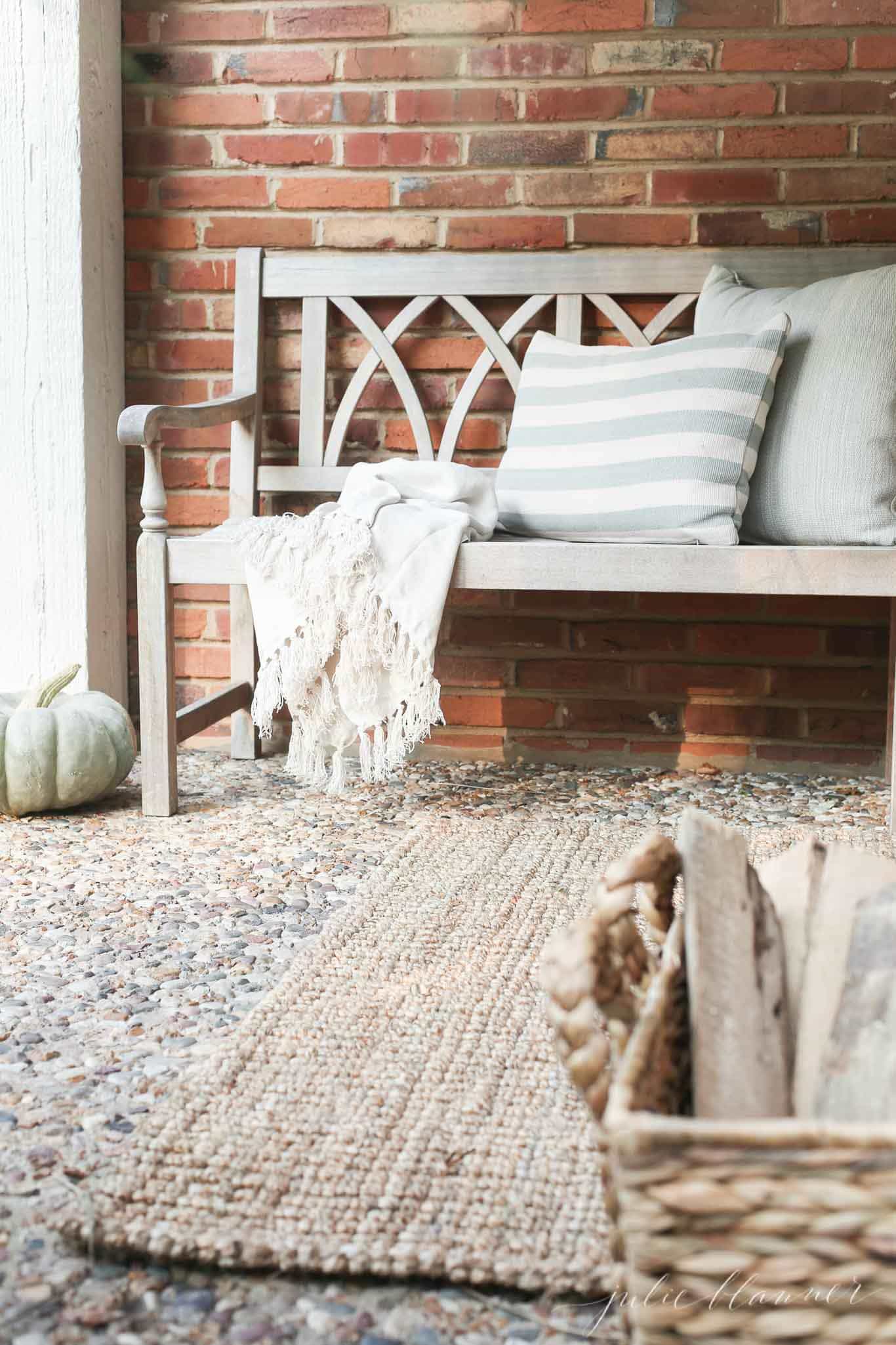 how to decfall porch with cozy throw, pillows and basket of wood 