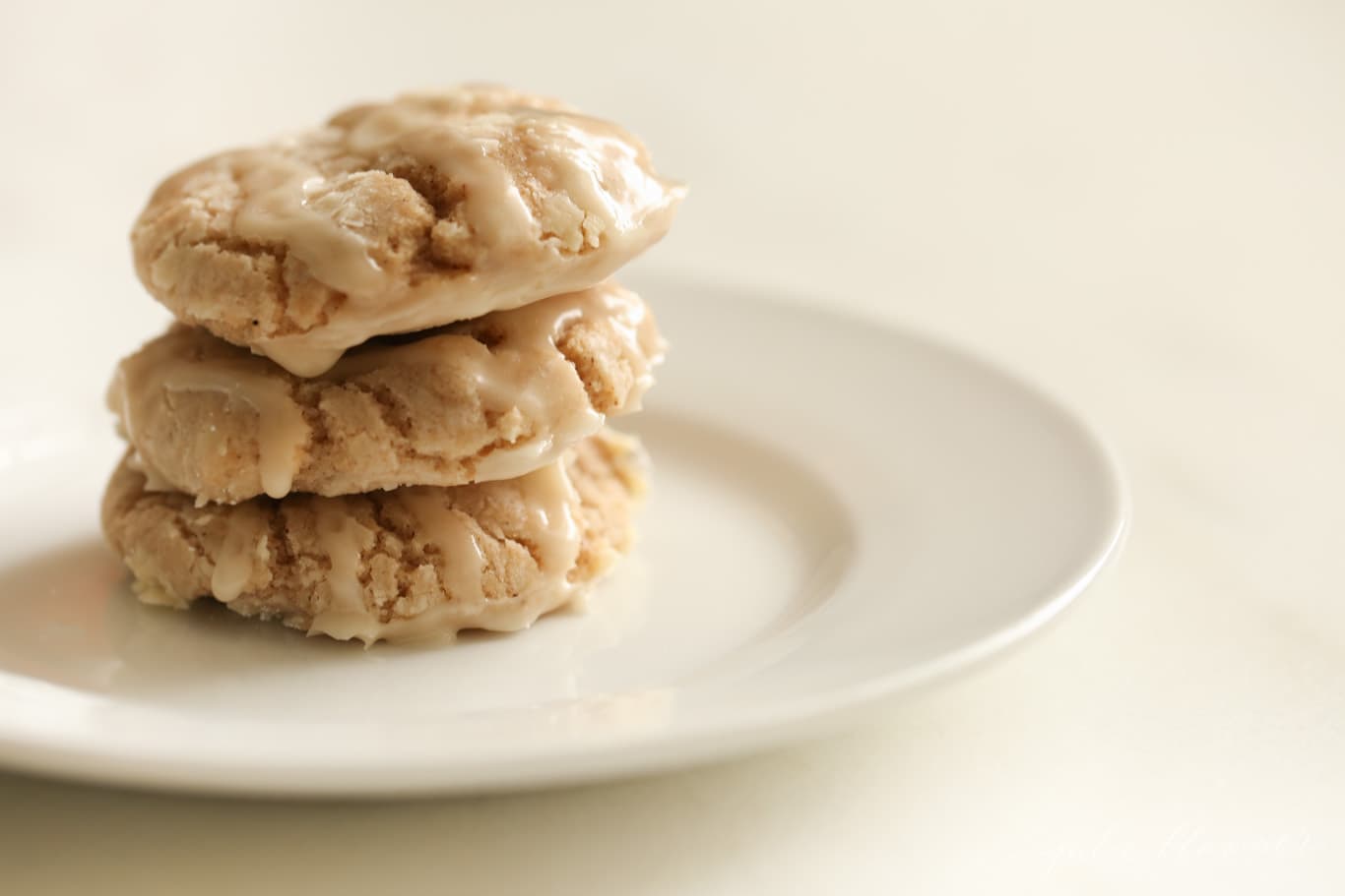 Three Glazed Apple Pie Spice Cookies on a white plate