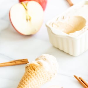 A bowl of apple infused ice cream with cinnamon sticks.