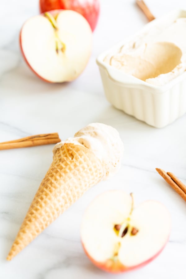 An apple ice cream cone with cinnamon sticks.
