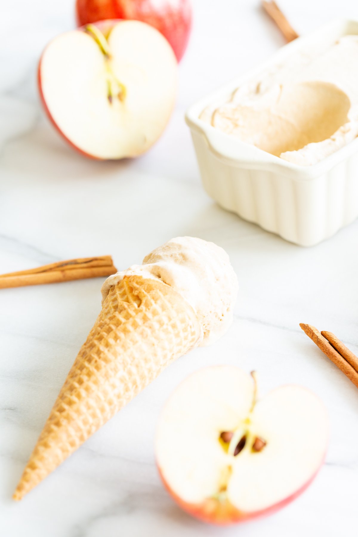 An apple ice cream cone with cinnamon sticks.
