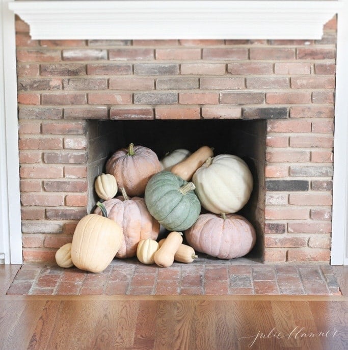 pretty fall decorating idea heirloom pumpkins spilling out of fireplace
