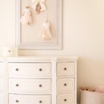 cream bedroom with pin board dresser and basket of stuffed animals
