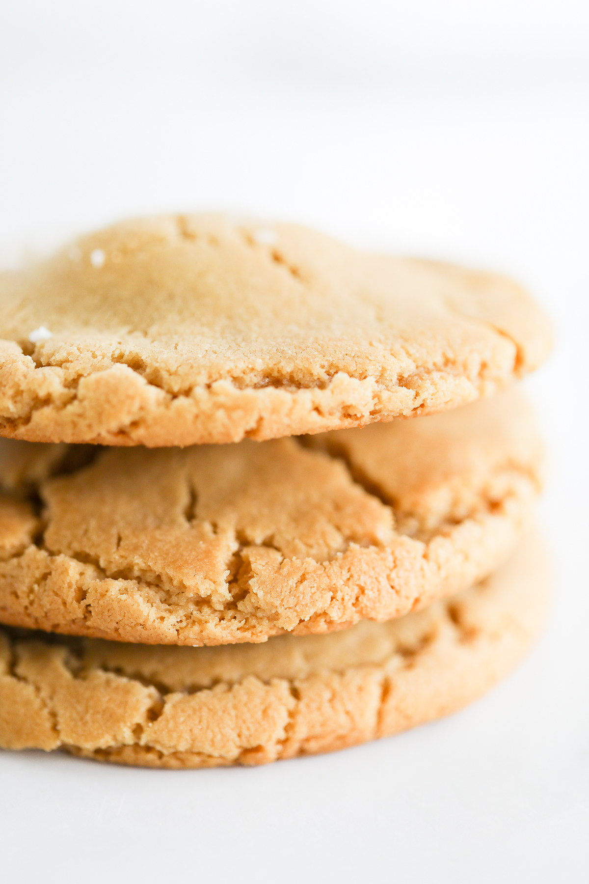 A stack of stuffed peanut butter cookies on a white surface.