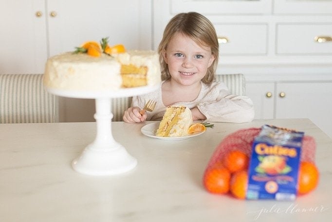 A little girl eating a slice of mandarin orange cake