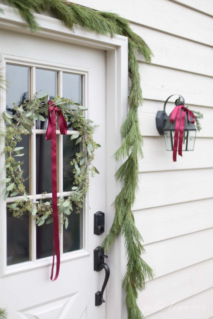 Simple Christmas door decorations with fresh greenery and ribbon