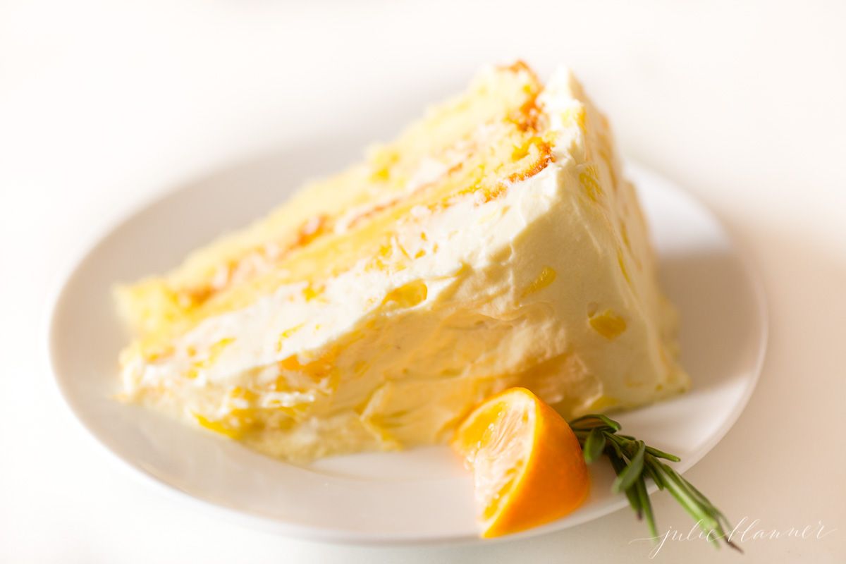 A slice of mandarin orange cake on a white plate.