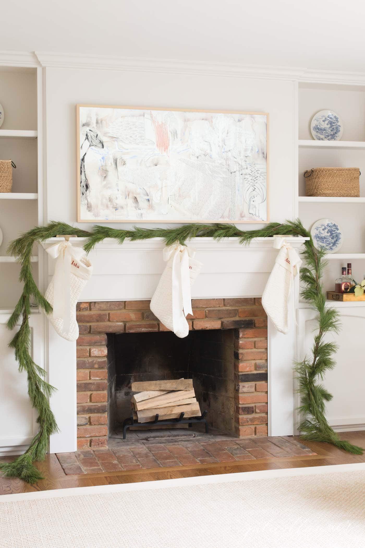 tv over fireplace mantel with christmas pine garland