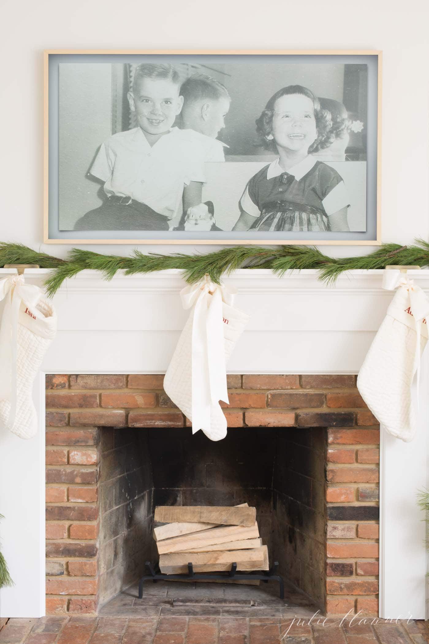 TV above fireplace with garland and stockings