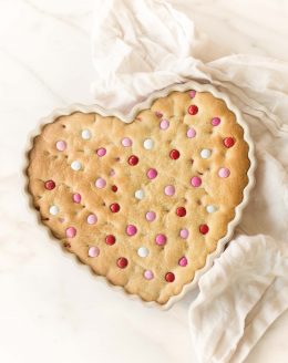 thick chewy m&m cake in heart shaped dish