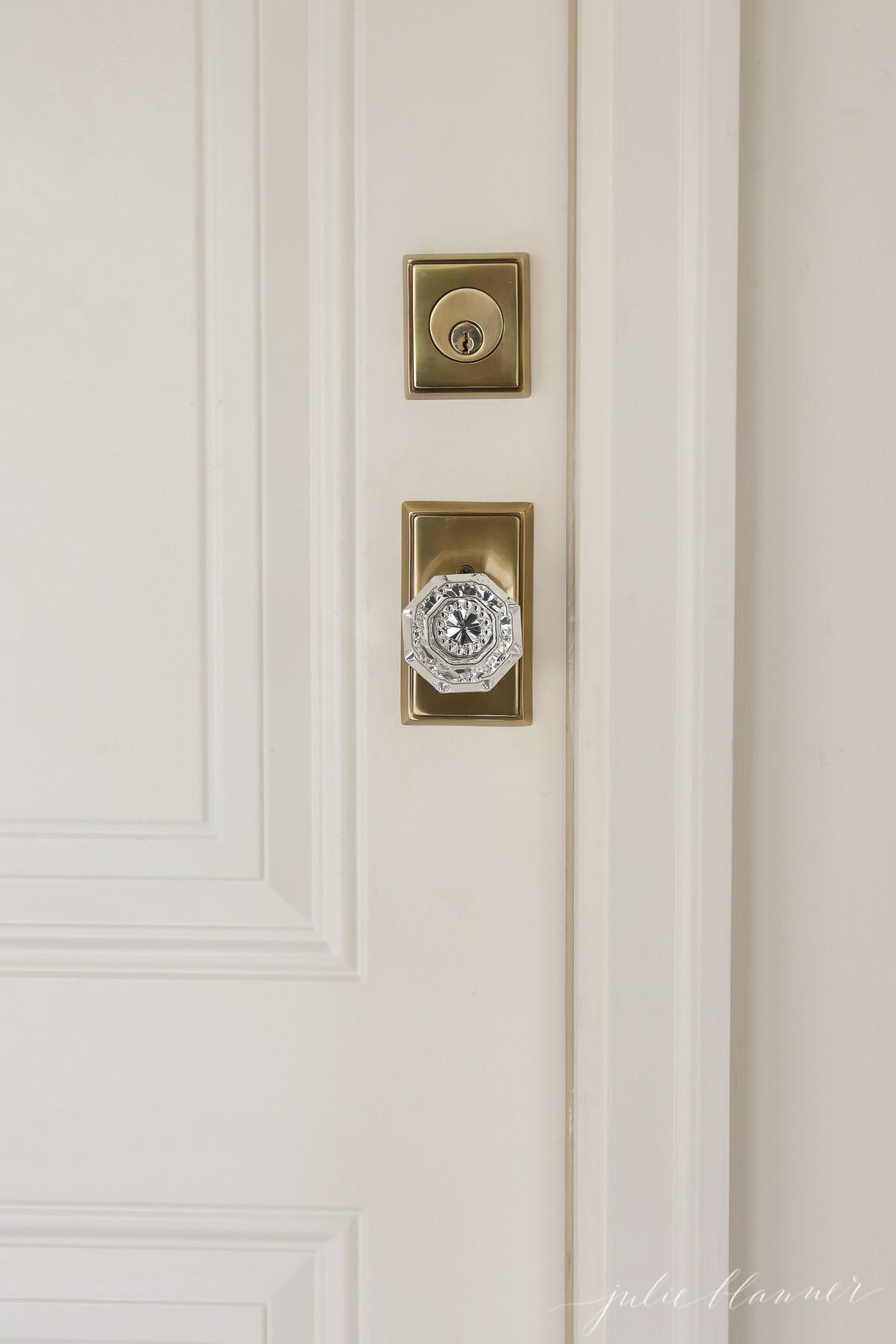 A cream painted door with brass and glass door knob.