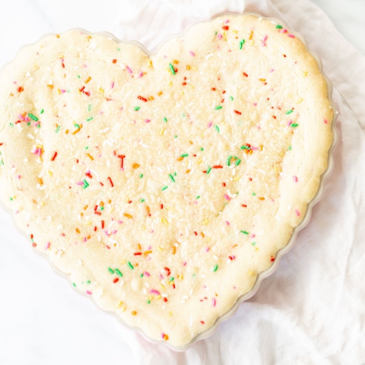 A funfetti cookie cake baked into a heart shaped pan.
