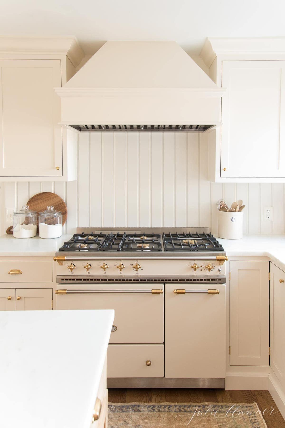 cream kitchen with sugar jars next to french range 