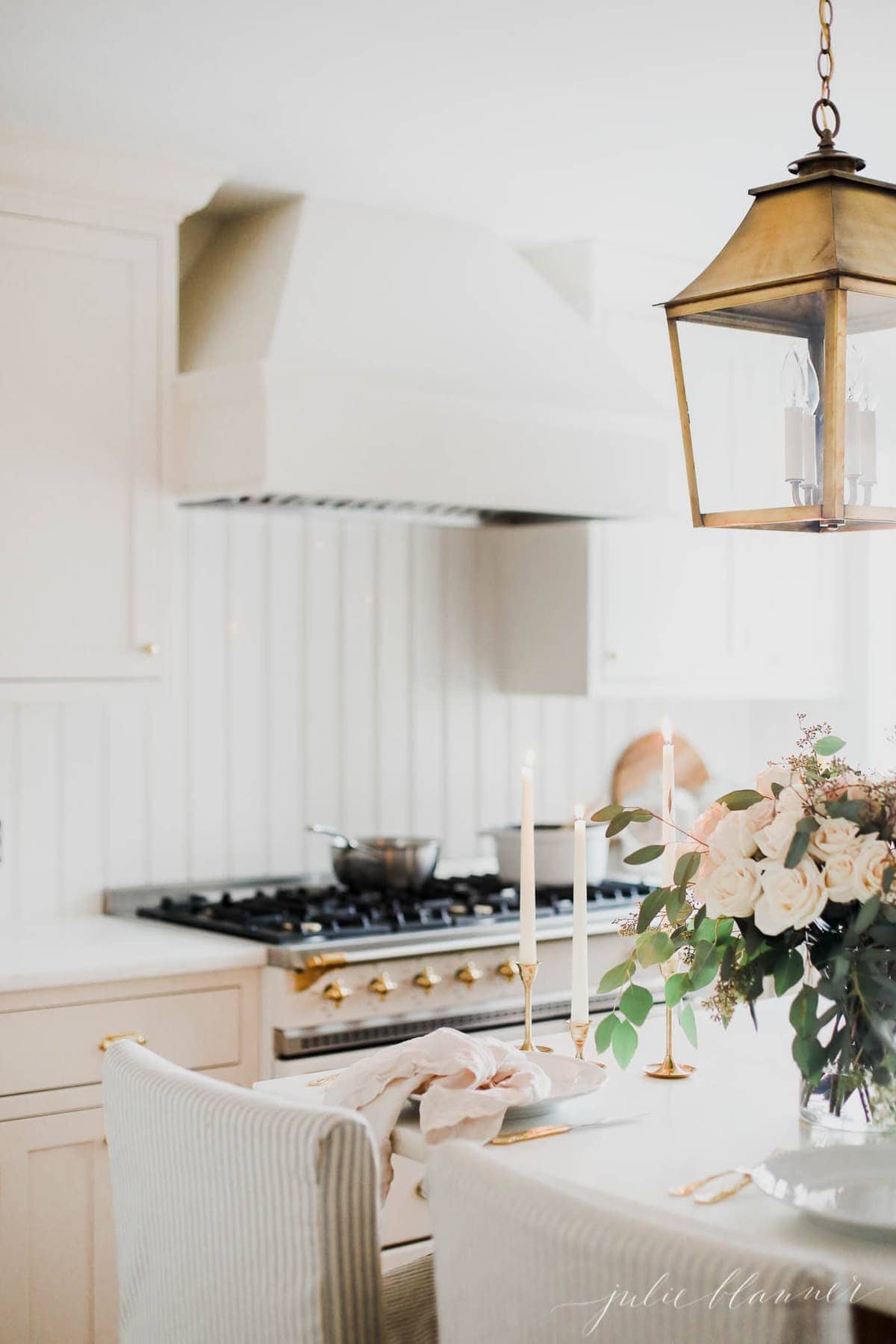 cream kitchen with brass lighting and lacanche range