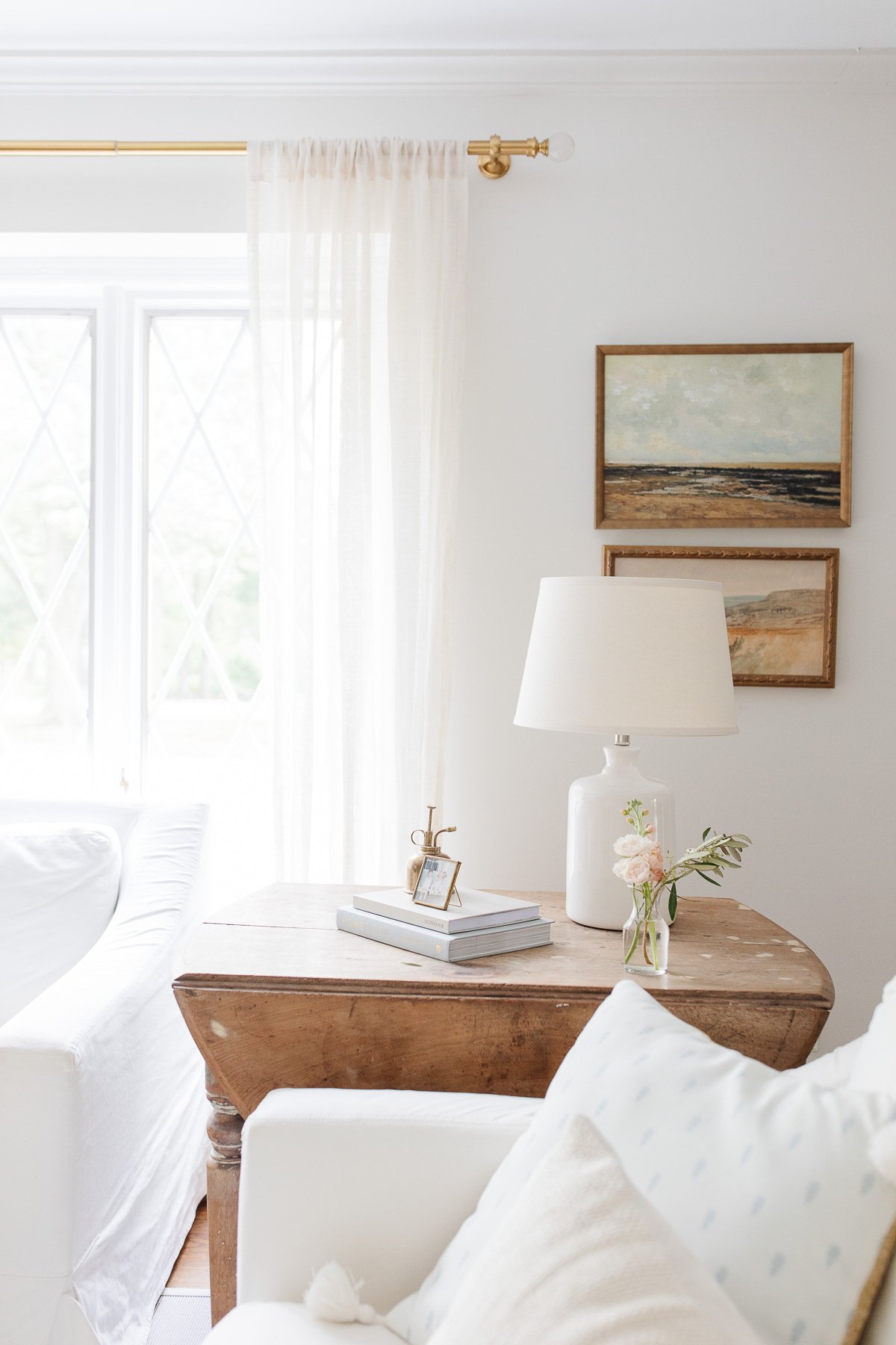 living room with stacked art and raw wood table