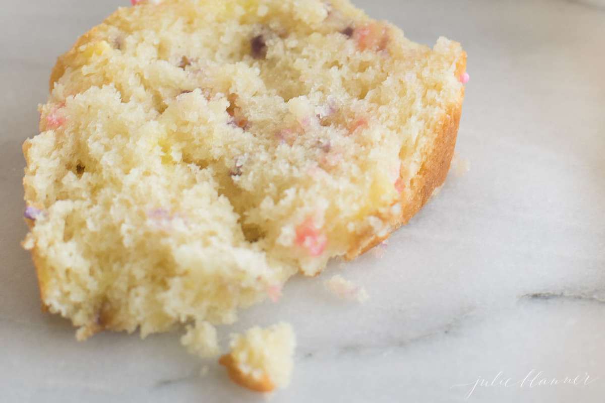 A slice of funfetti quick bread on a marble surface