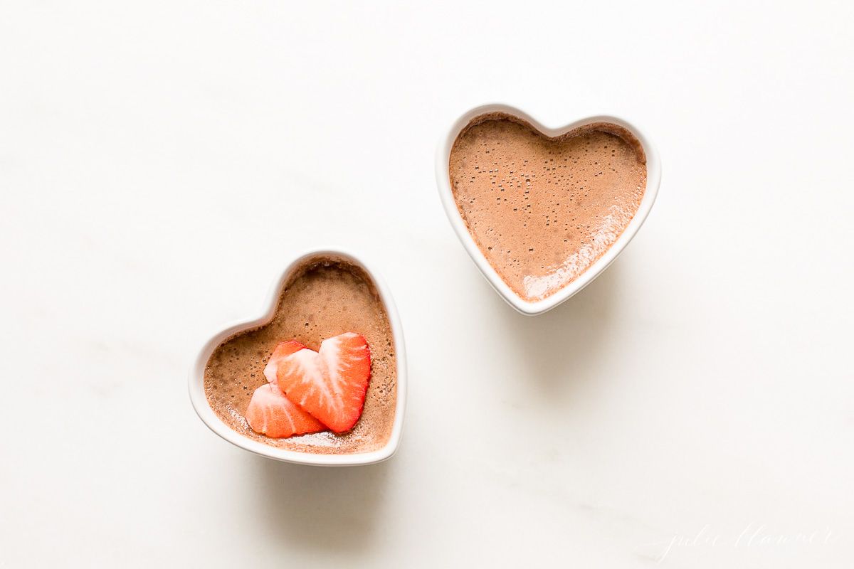 two small heart shaped ceramic containers of chocolate pots de creme