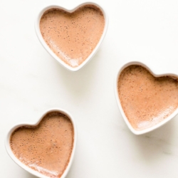 Three small heart shaped ceramic containers of chocolate pots de creme