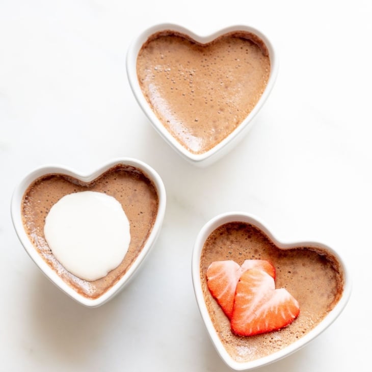 Three small heart shaped ceramic containers of chocolate pots de creme
