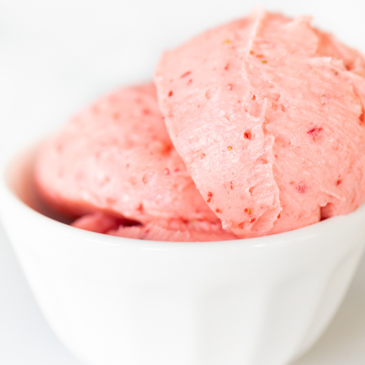 A white bowl full of strawberry butter.