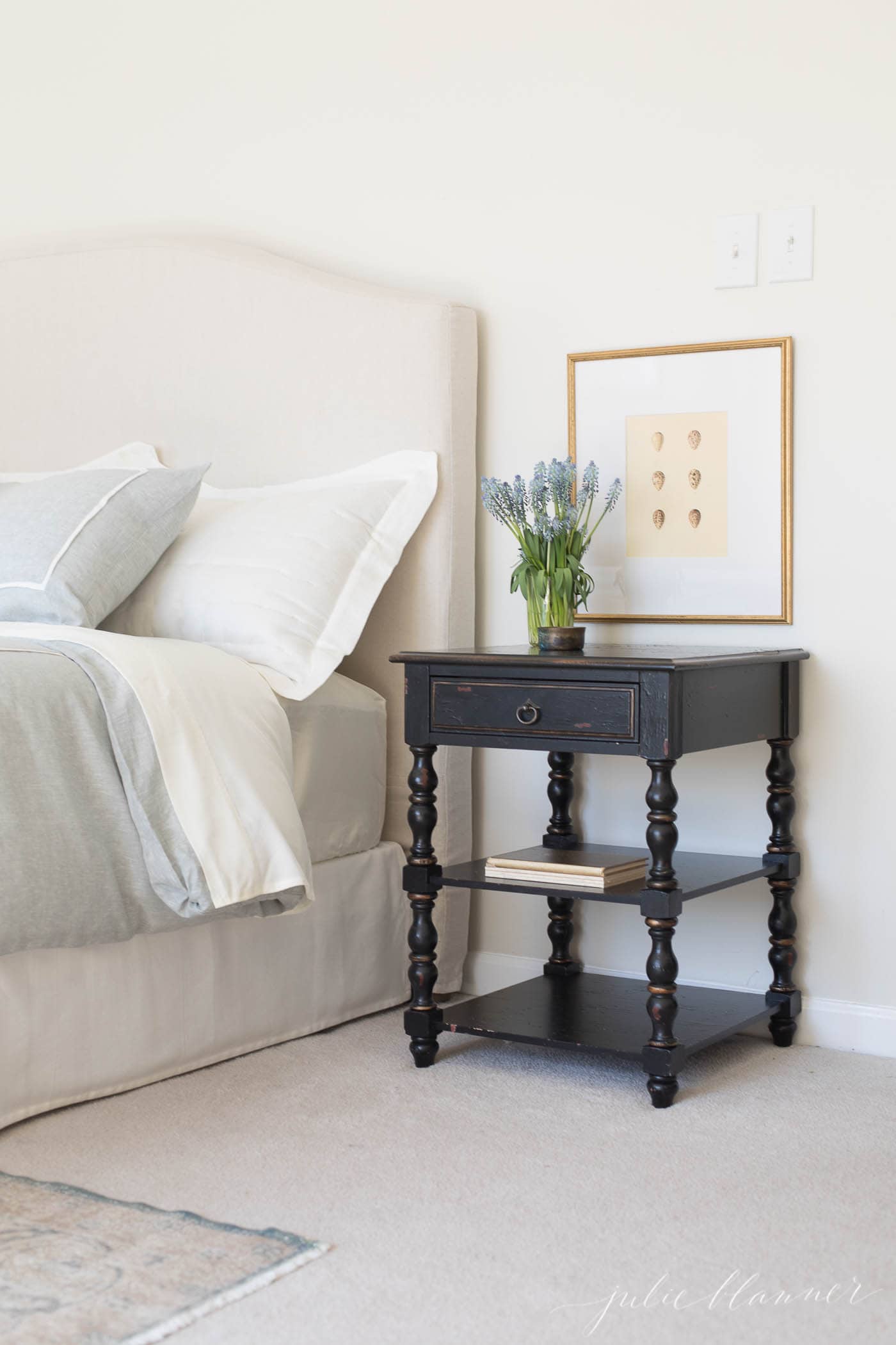 A bedroom with a linen headboard and linen bedding