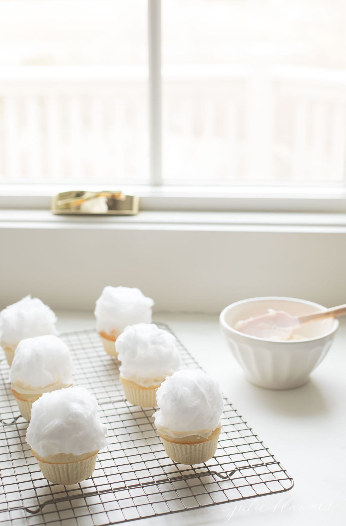 white Easter cupcakes topped with cotton candy to make bunny tails