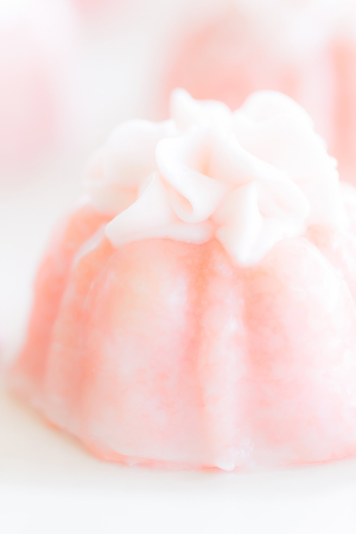 Close-up image of a pink champagne cupcake with delicate icing on top.