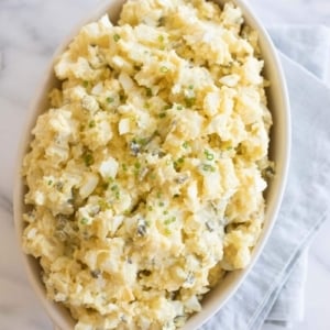 homemade potato salad with eggs in a white casserole dish