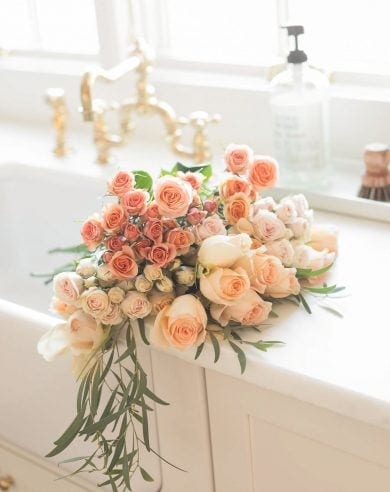 peach flowers in apron front sink