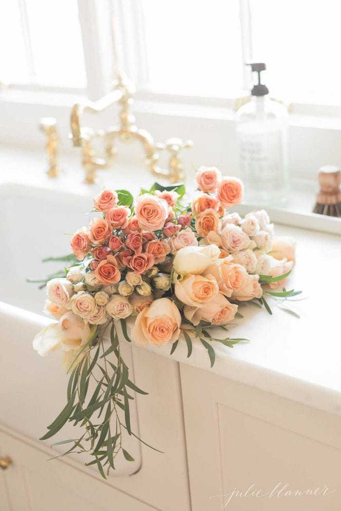 peach flowers in apron front sink