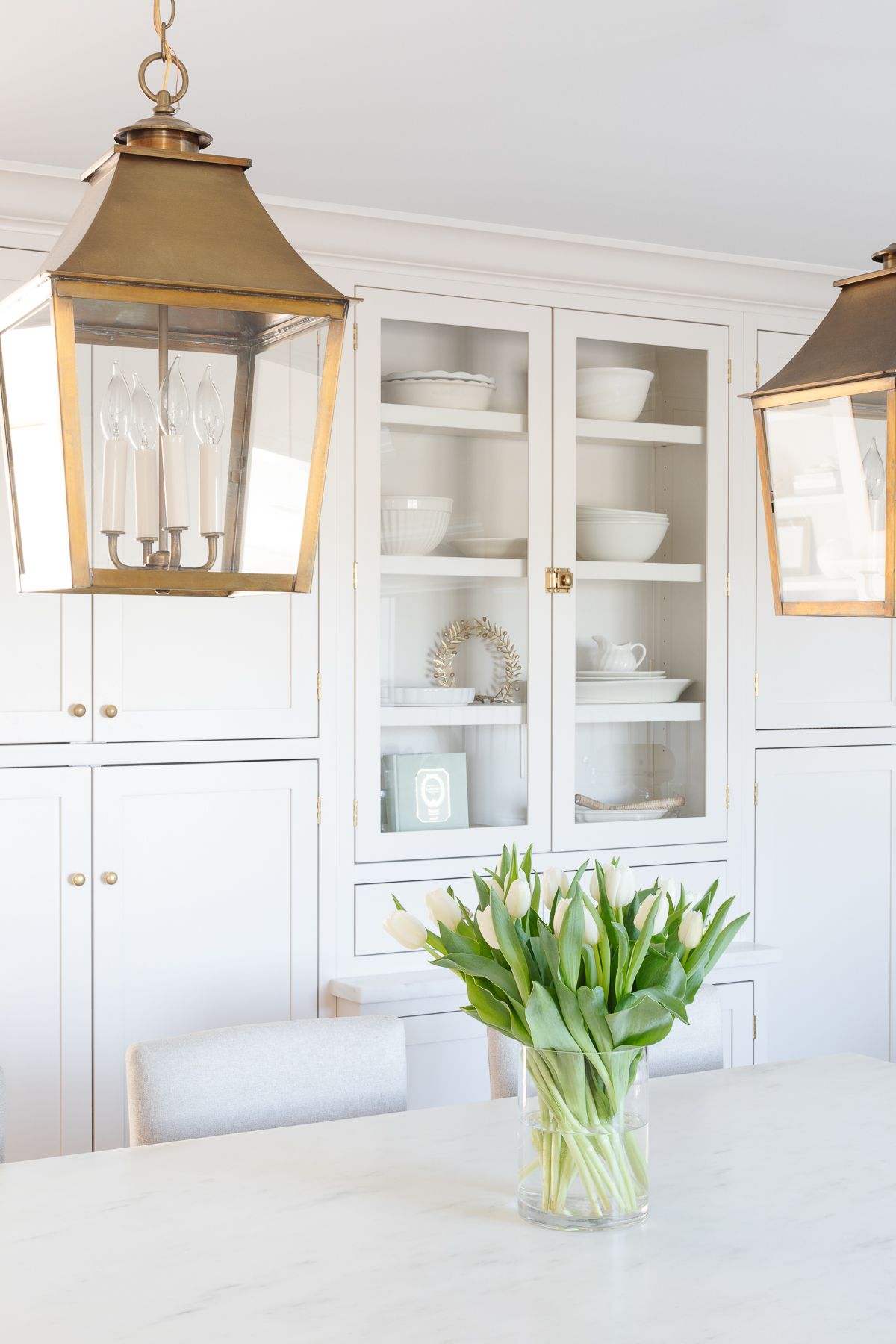 A white tulip arrangement on a marble island countertop.