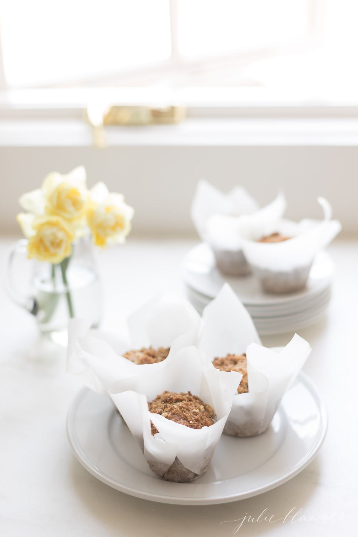 banana muffins in paper wrappers on a white plate