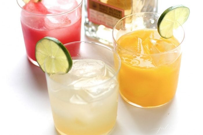 A simple and refreshing Mango Margarita recipe. This cocktail is full of summer flavors and quick and easy to make! It's the perfect drink for Cinco De Mayo mango margaritas garnished with a slice of lime