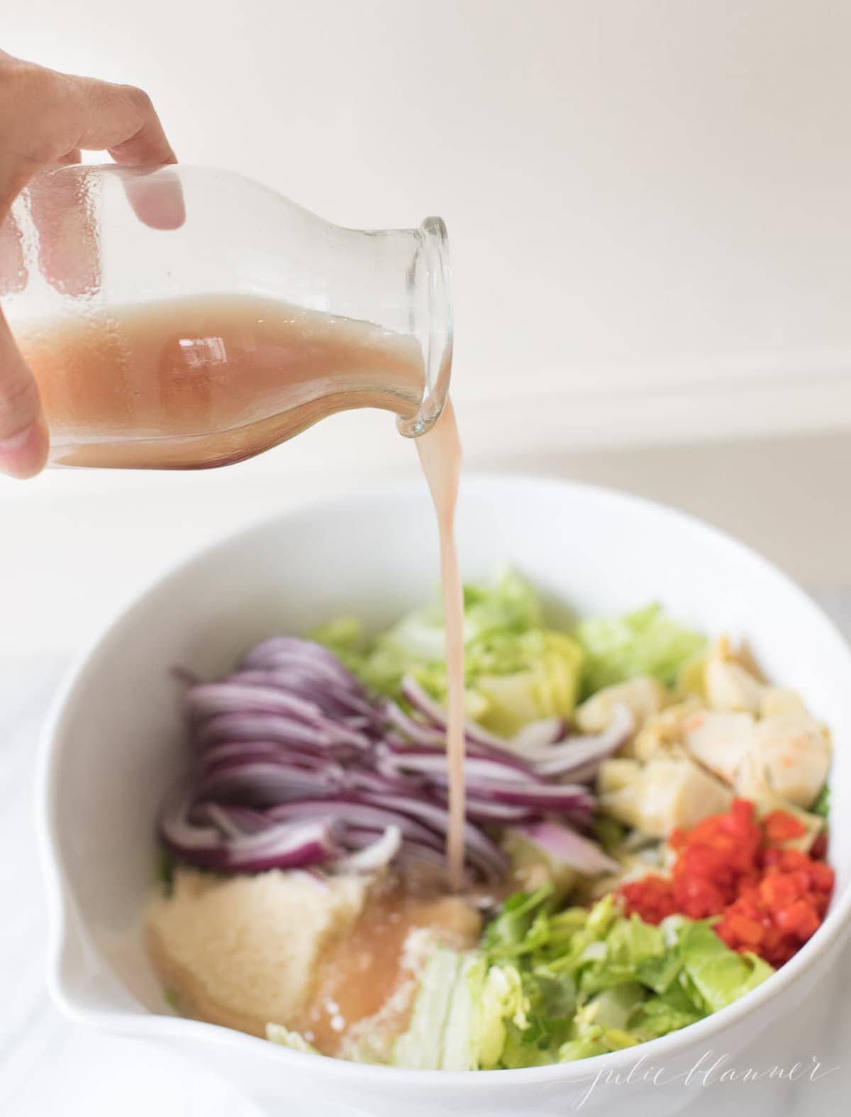 red wine vinaigrette being poured over salad