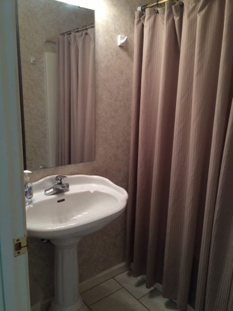 A bathroom before being remodeled; brown accents. 