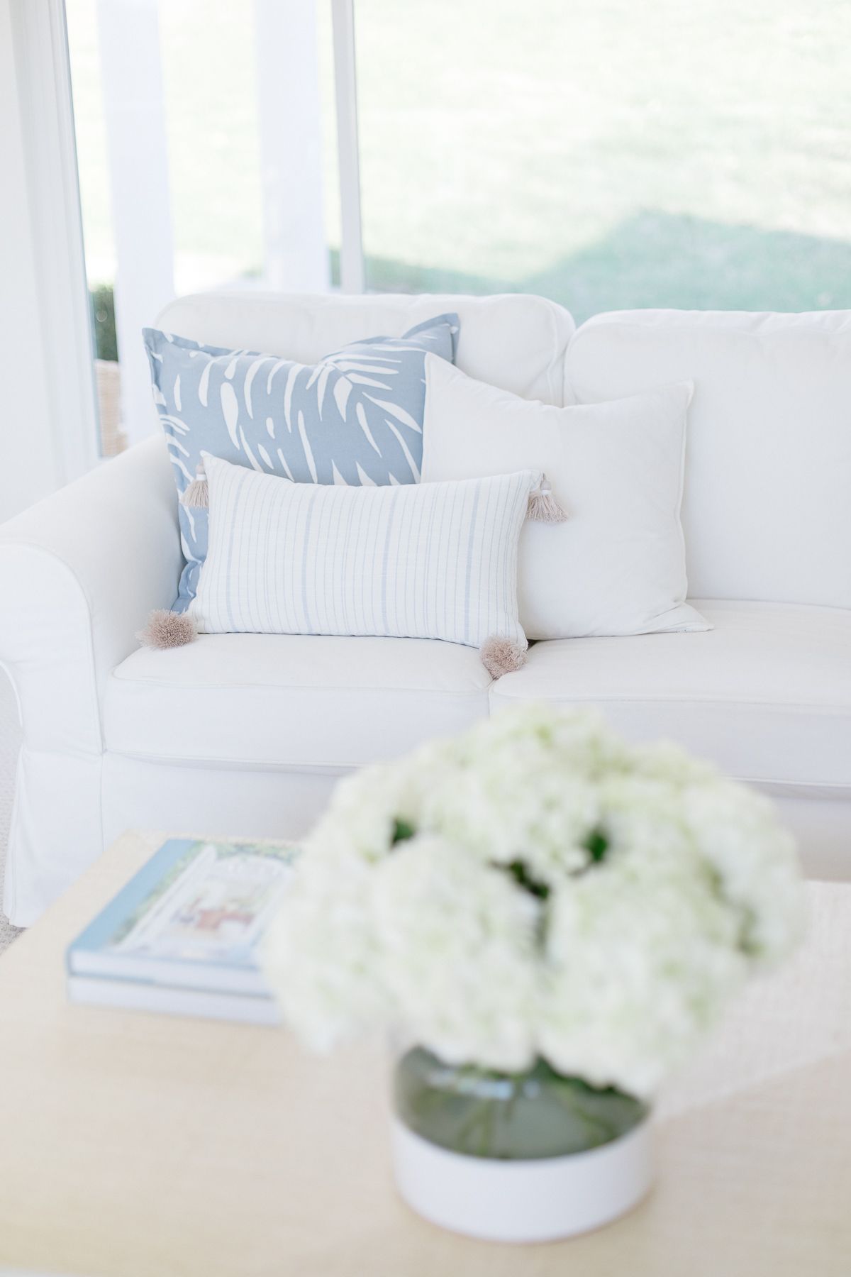 A white living room with white sofas and coastal decor