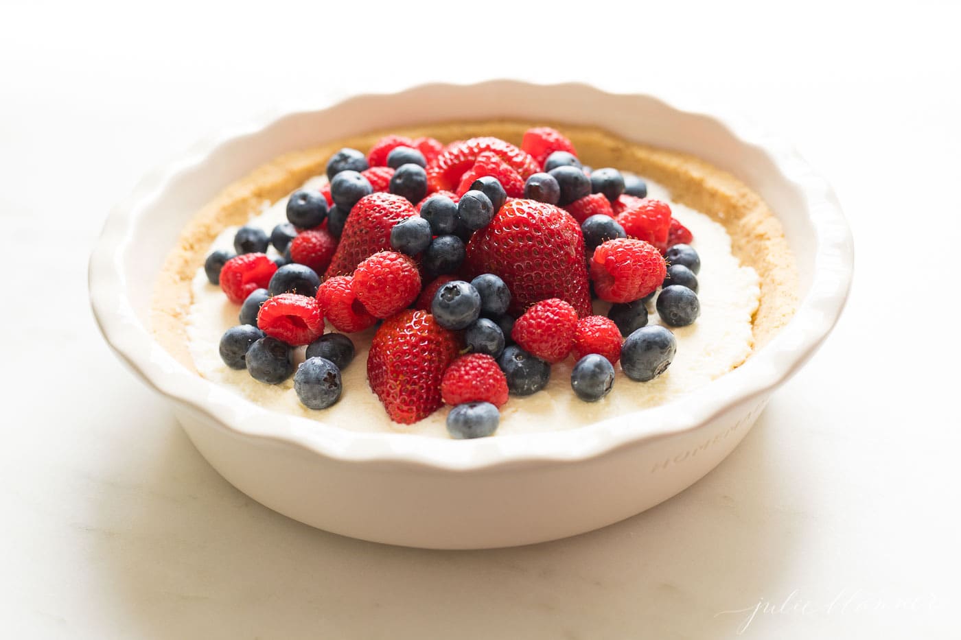 pie dish filled with lemon creme and berries