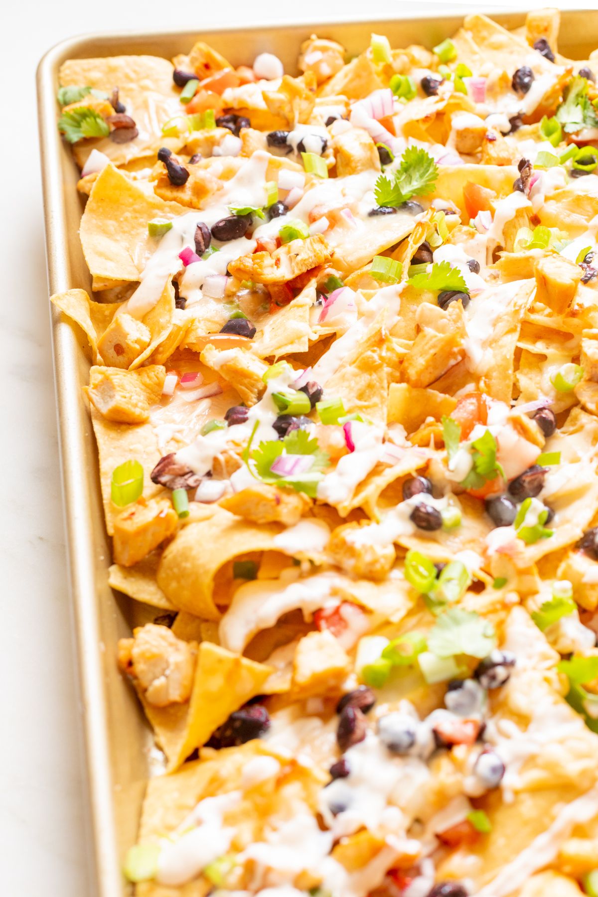 Chicken nachos on a sheet pan.