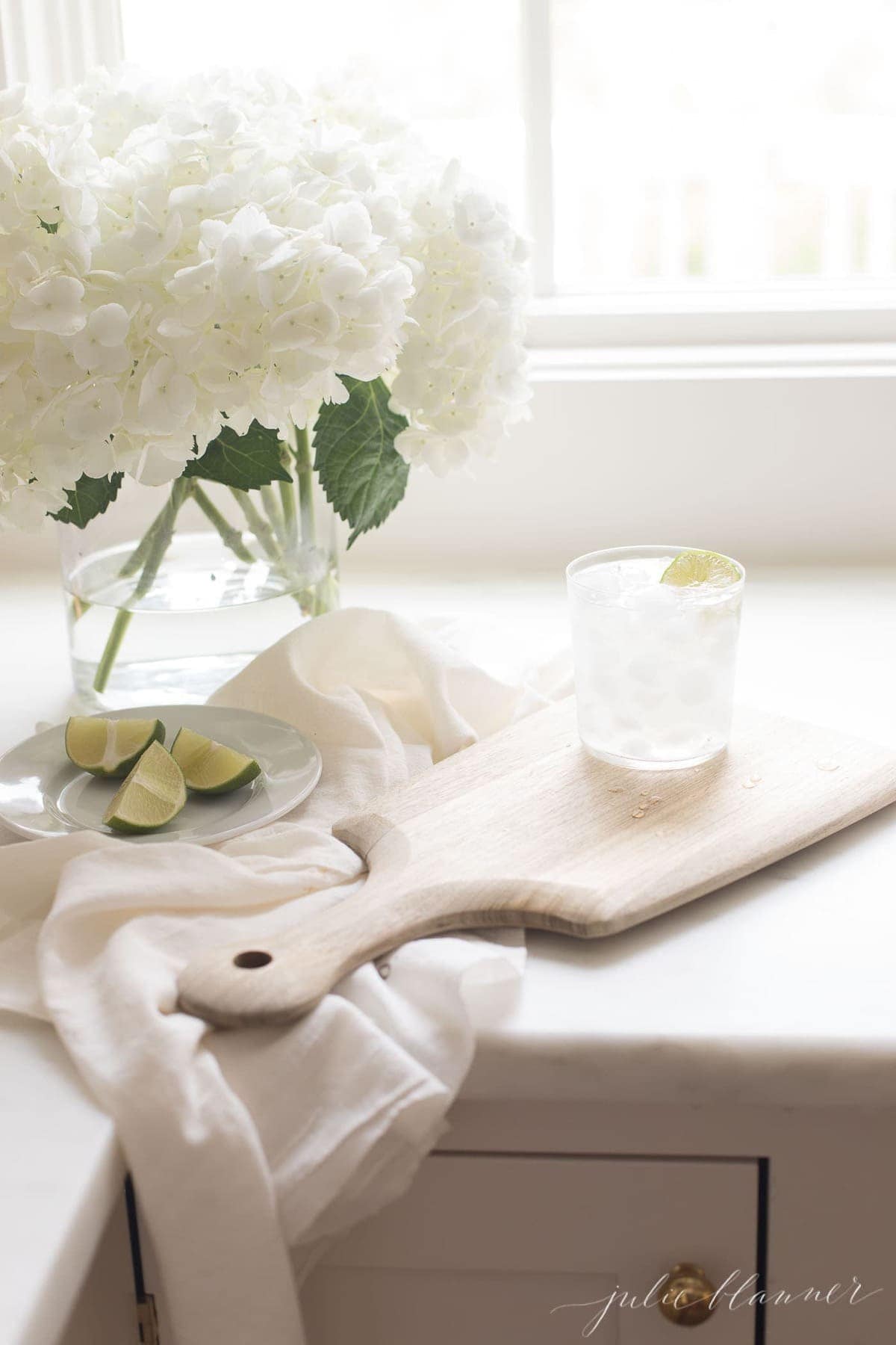 White surface with a glass filled with a paloma cocktail recipe on ice.