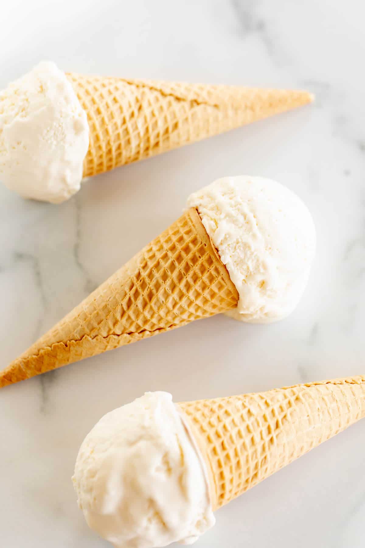 three ice cream cones on marble surface