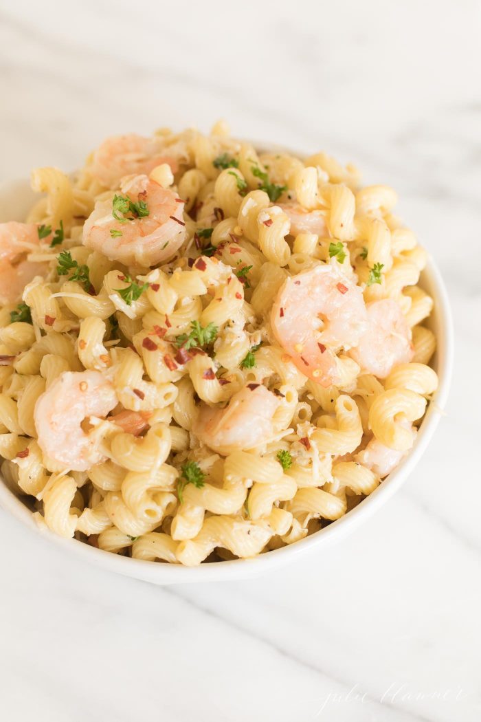 A white bowl filled with a seafood pasta salad recipe.