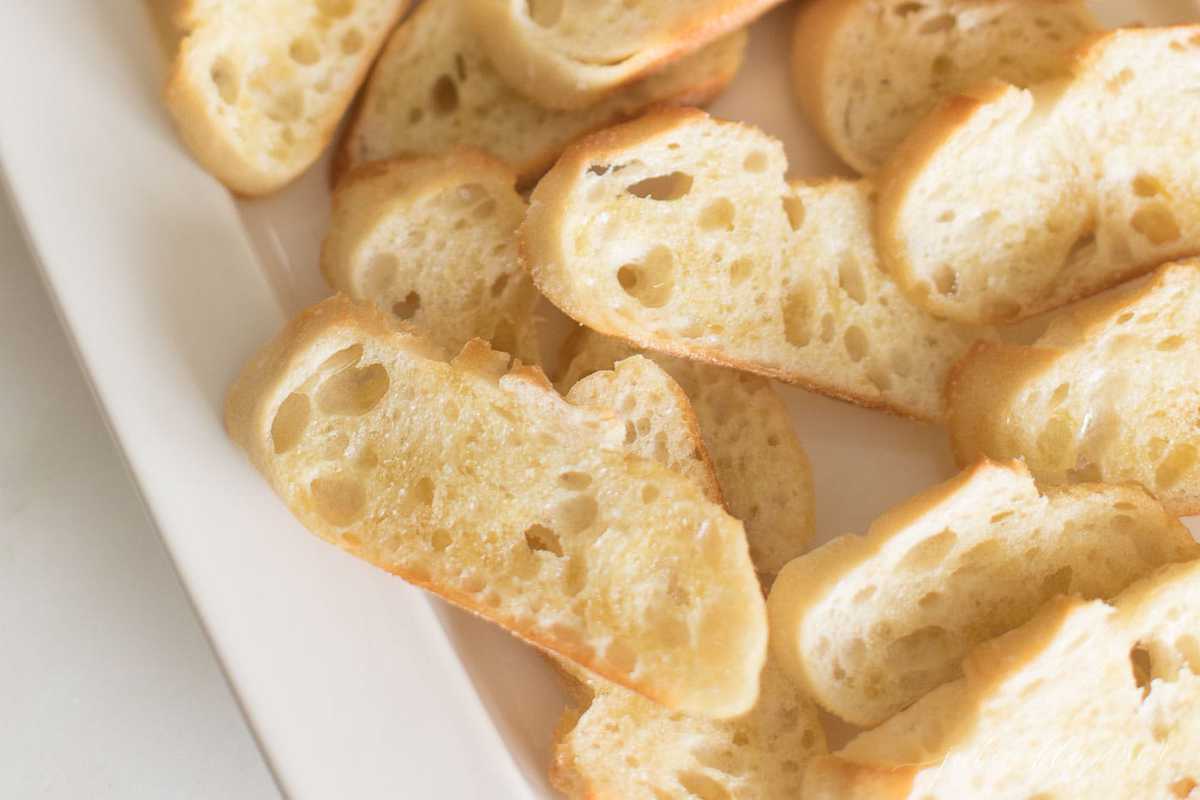 crostini brushed with olive oil on a white platter