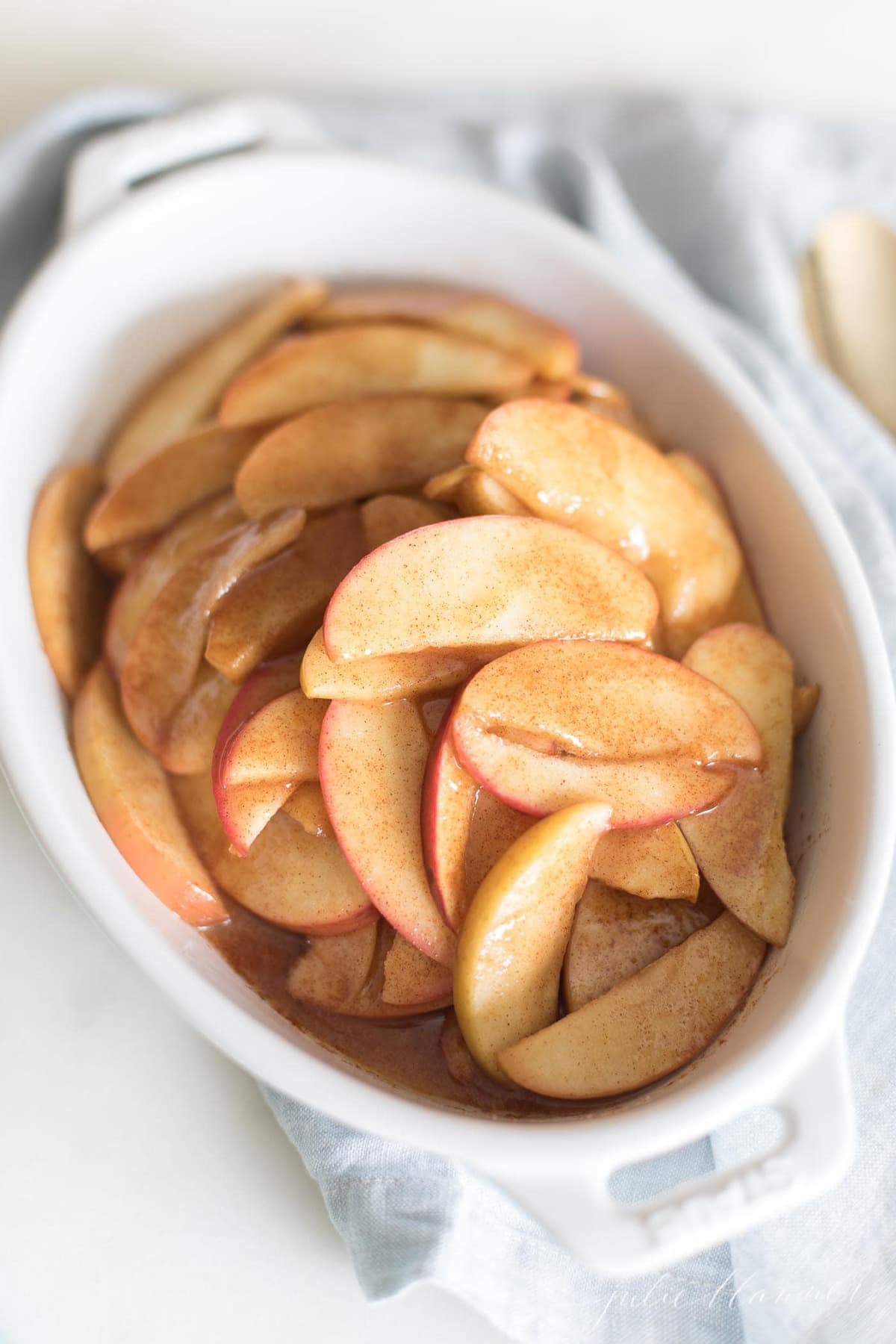 baked apples in a white baking dish