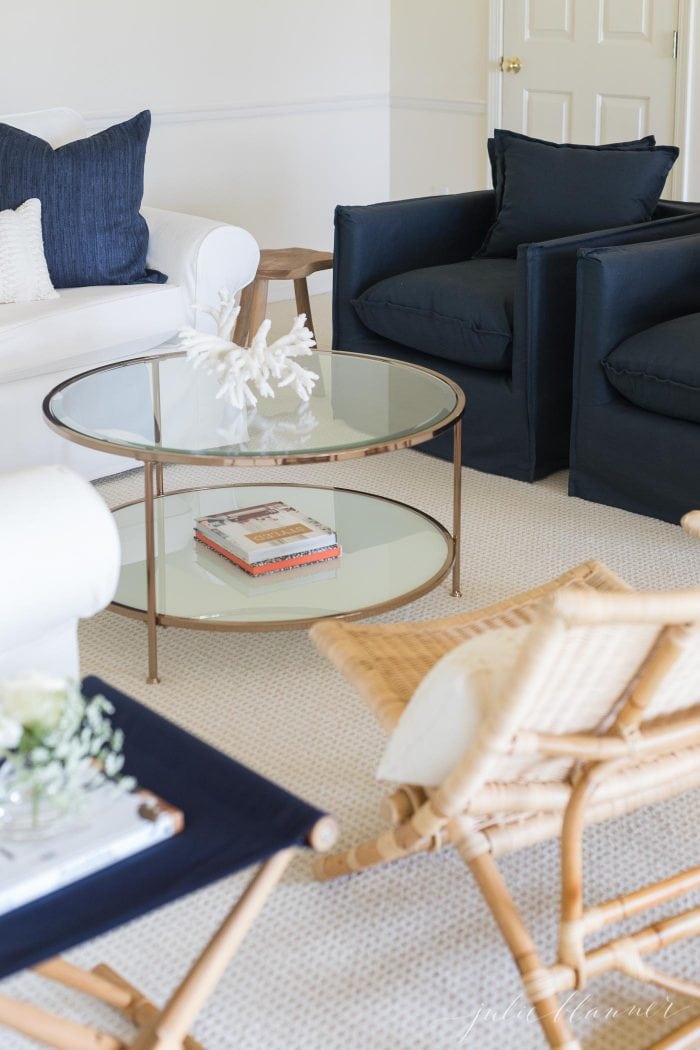 A modern living room with a round glass coffee table. 