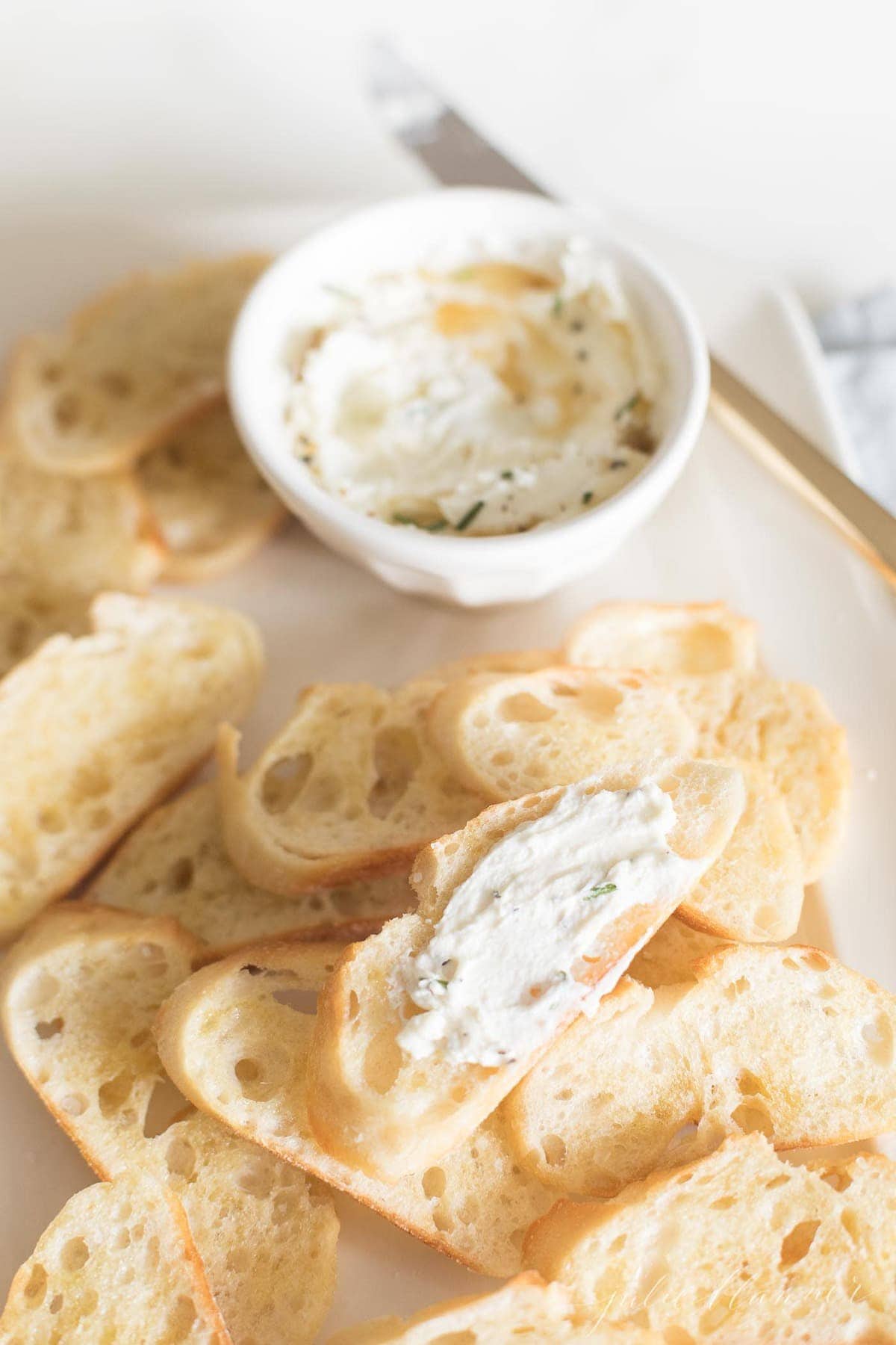 Whipped goat cheese with honey on a platter of crostini
