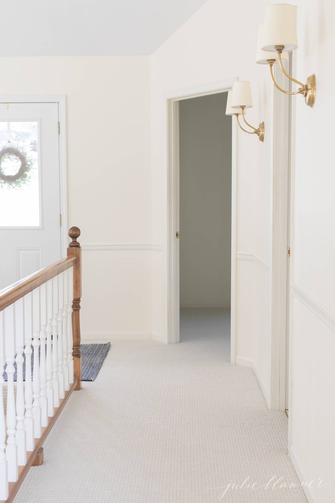 Wall to wall carpet in a hallway with white painted walls