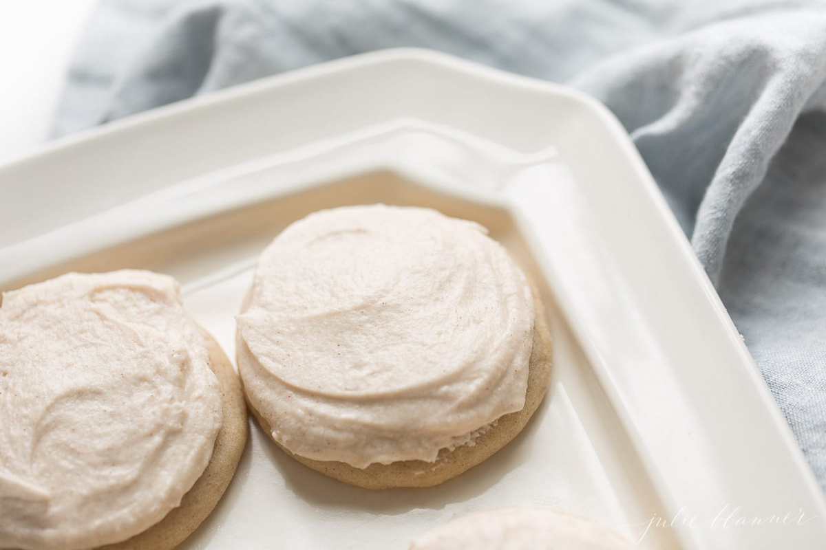 Two frosted cookies on a white plate